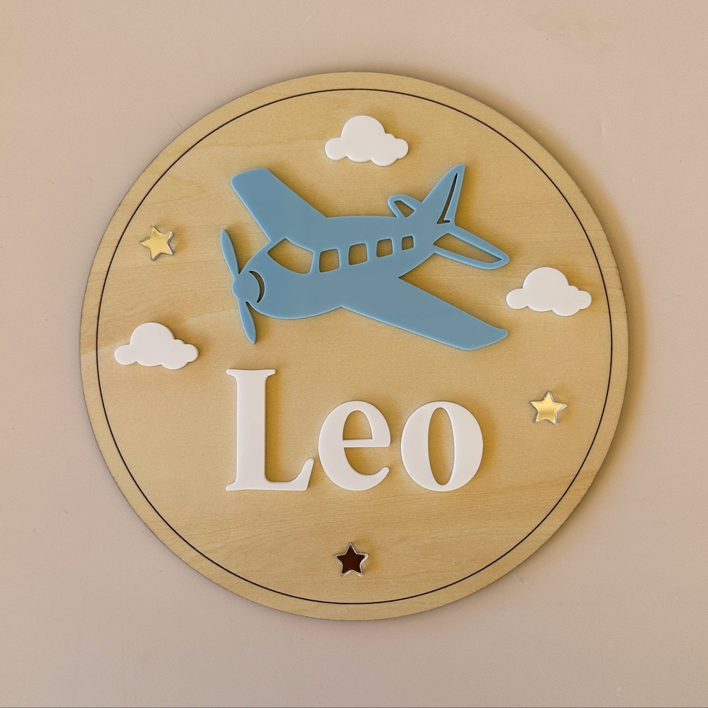 Wooden plaque with airplane and clouds design on a beige background